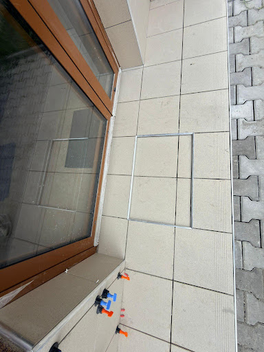 Detail osazení revizního rámečku a přesné zaříznutí dlažby u dveří